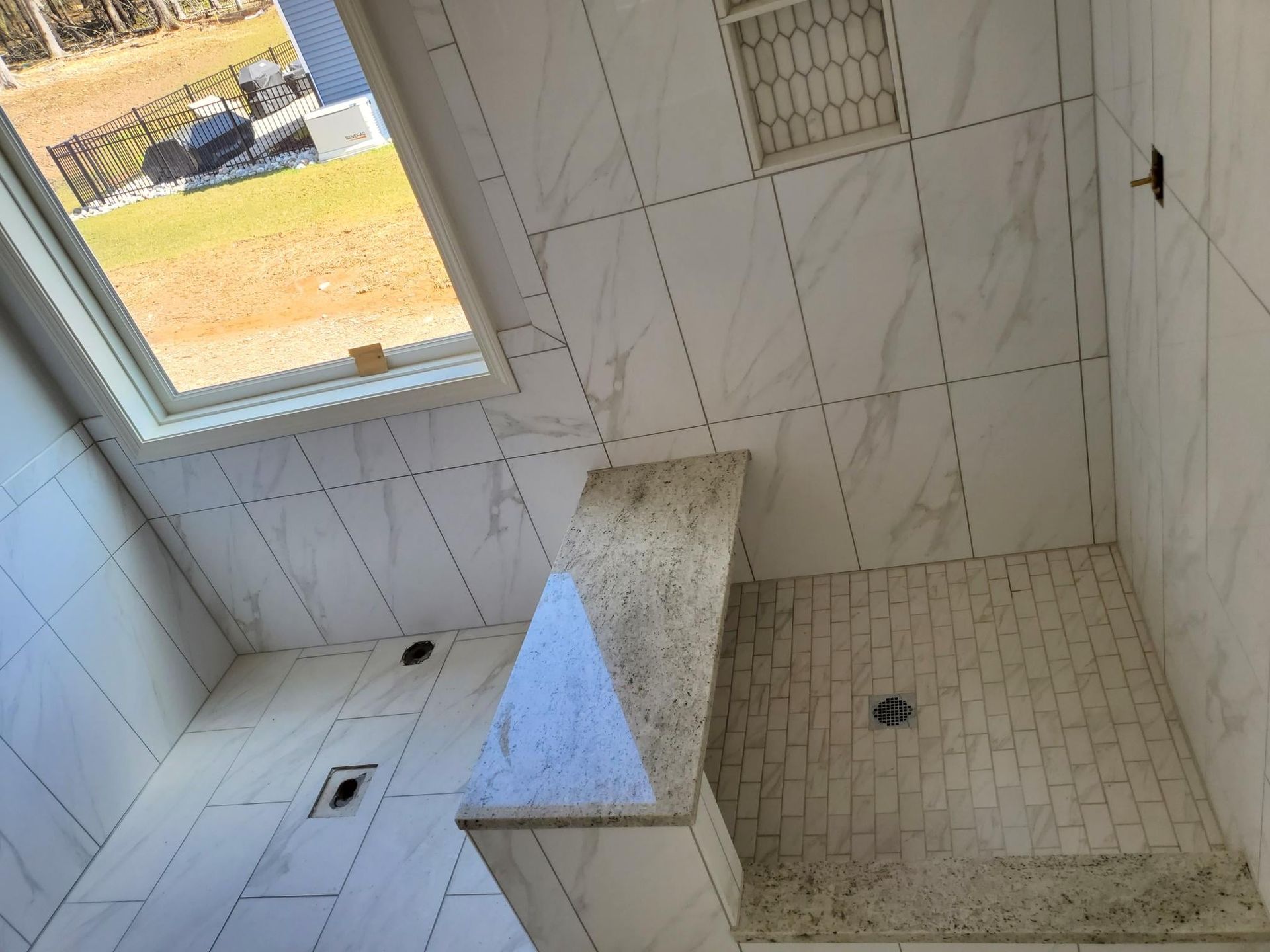 A bathroom with a walk in shower and a window.