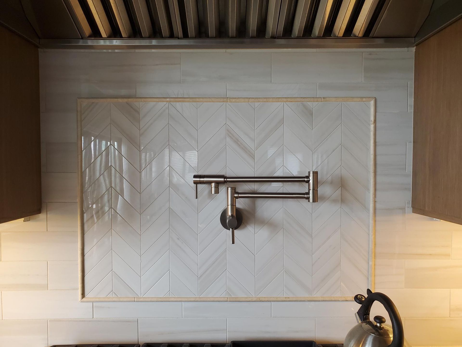 A kitchen with a stove top oven and a faucet on the wall.