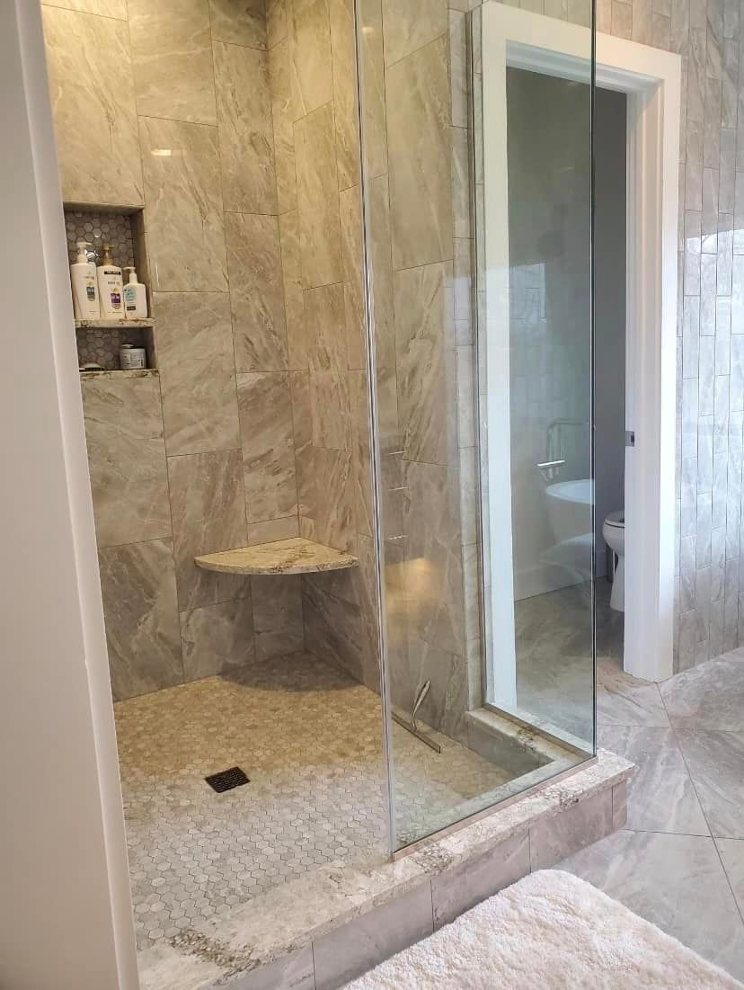 A bathroom with a walk in shower and a toilet.