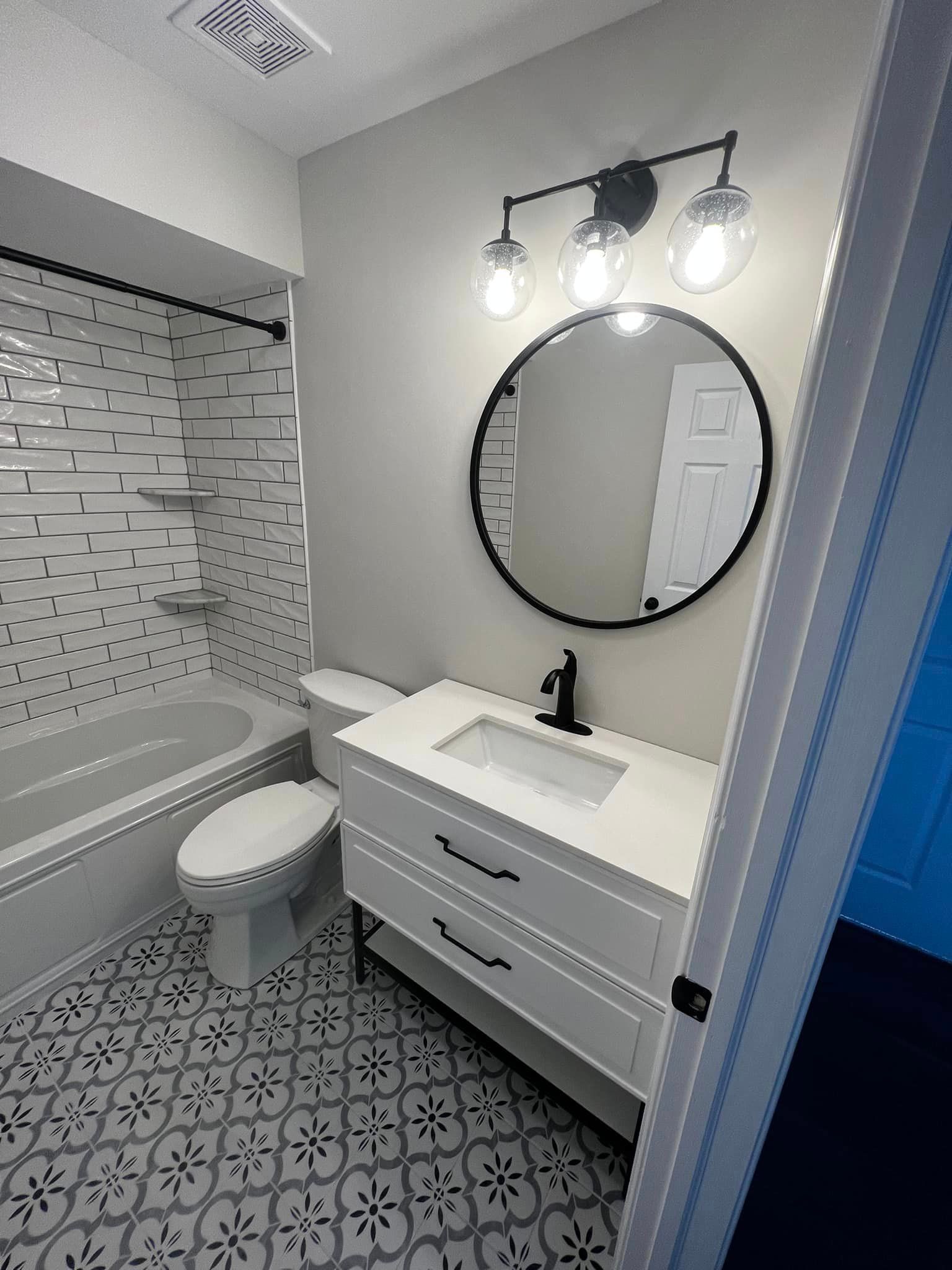 A bathroom with a sink , toilet , bathtub and mirror.