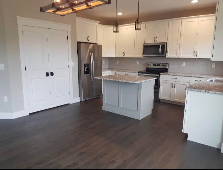 White shaker cabinets and granite, with a painted island in the middle.