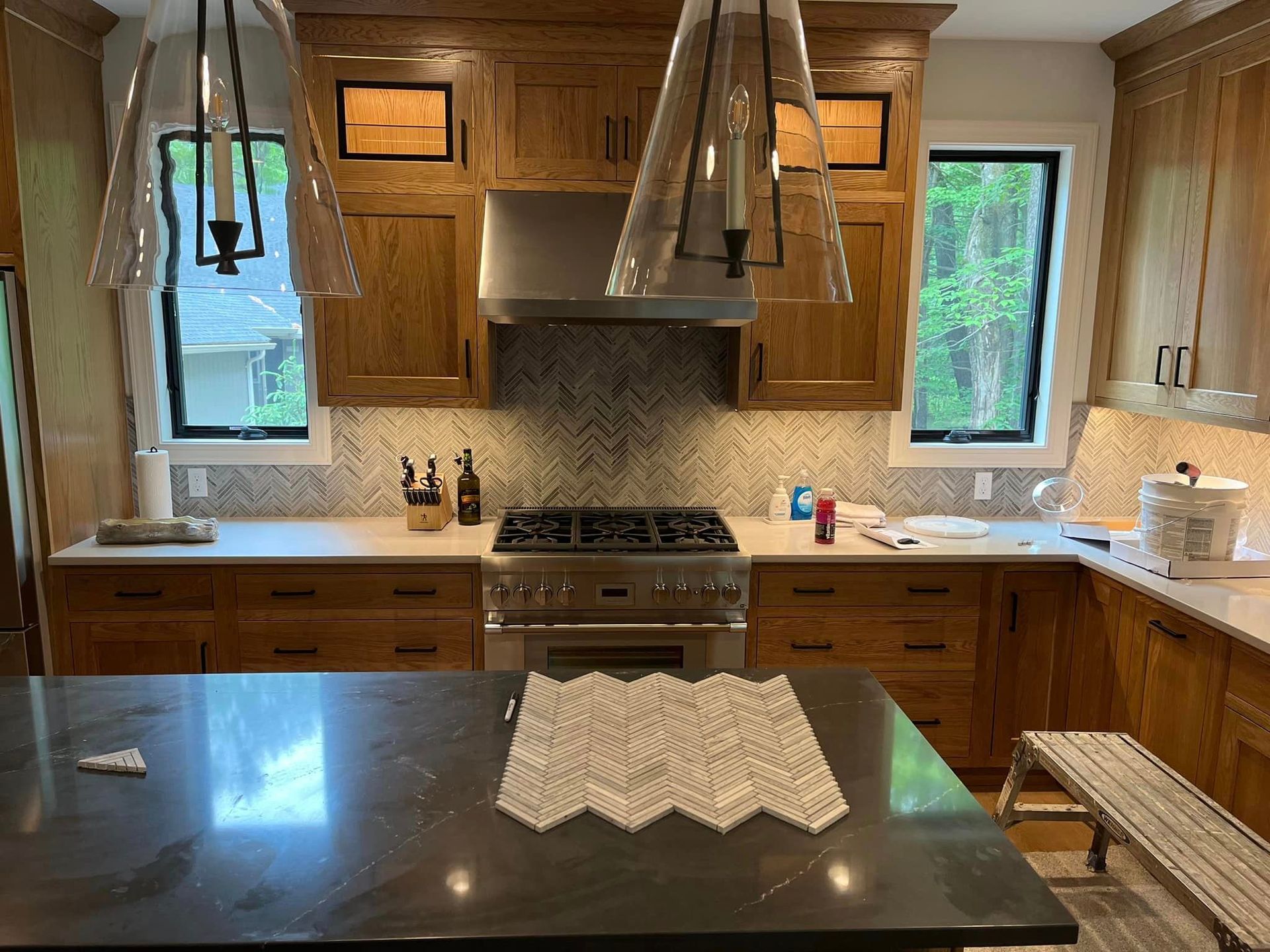 A kitchen with wooden cabinets , stainless steel appliances , and a large island.