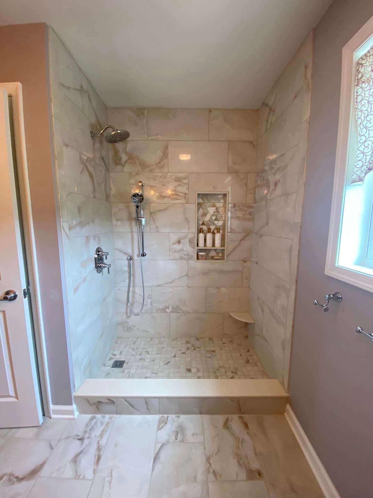 A bathroom with a walk in shower and a window.
