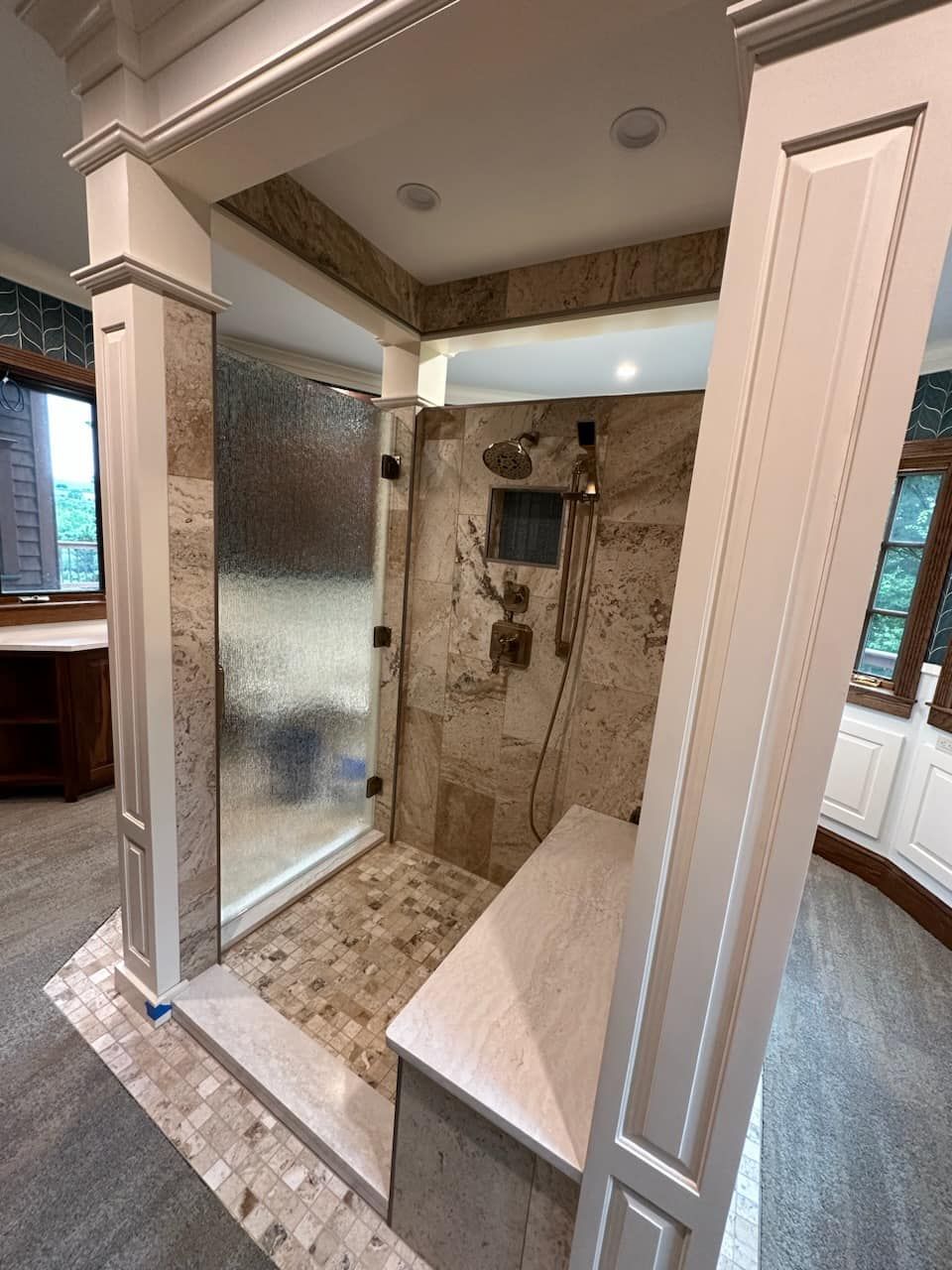 A bathroom with a walk in shower and a bench