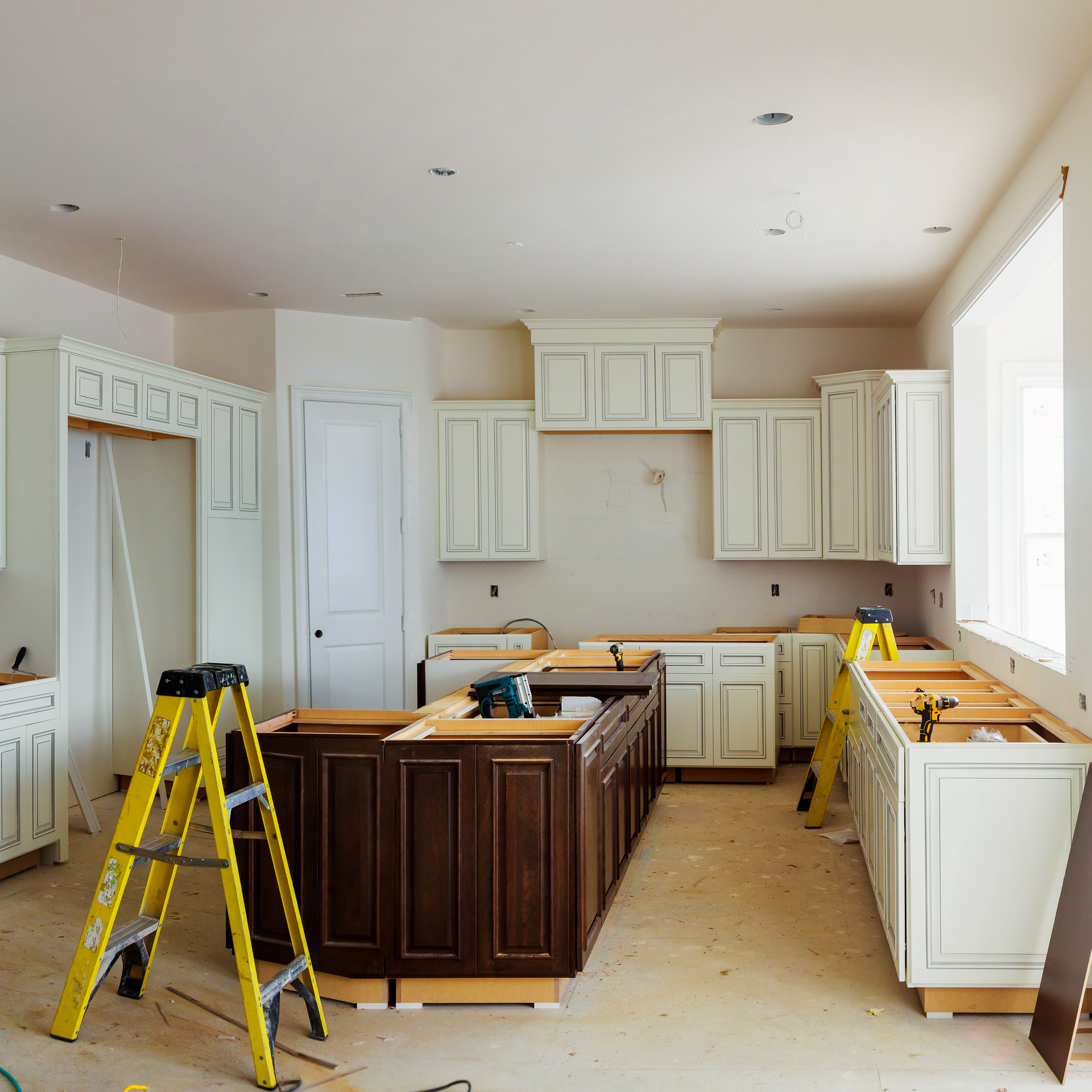 A kitchen under construction with a yellow ladder in the middle