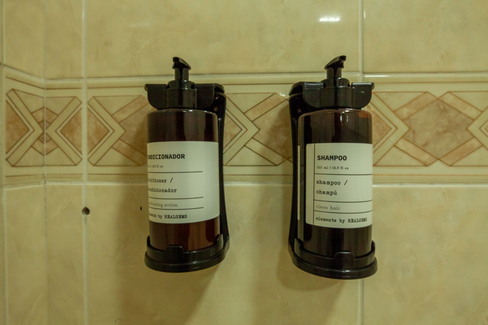 Duas garrafas de xampu marrons, com os dizeres 