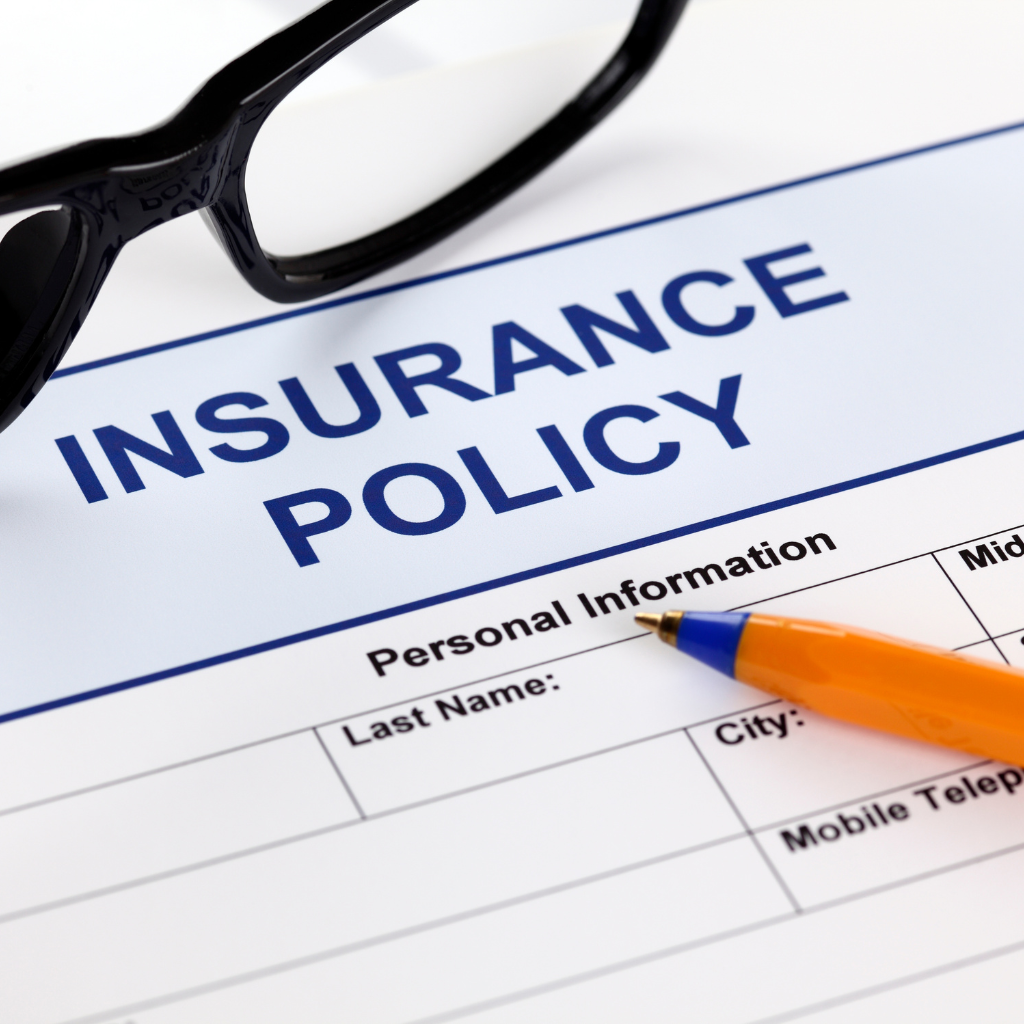 glasses and a paper with insurance policy written on it