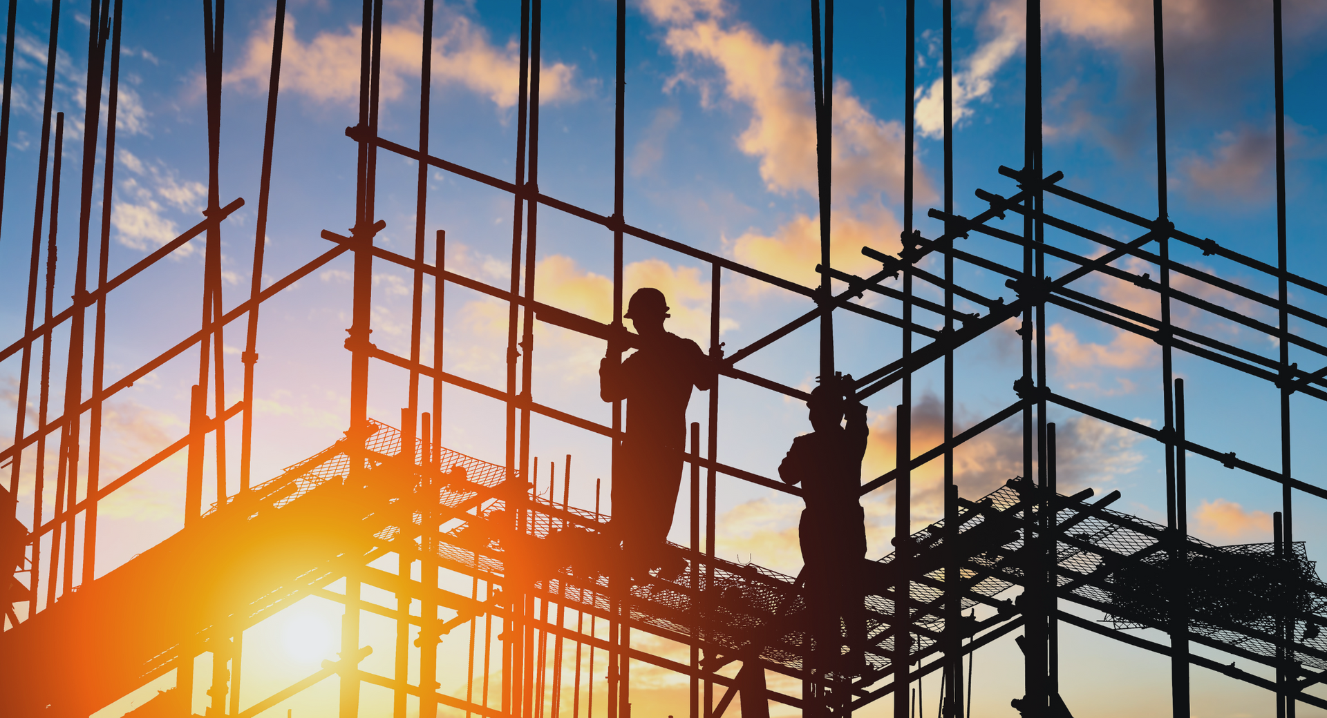 A silhouette of a construction worker with a torch