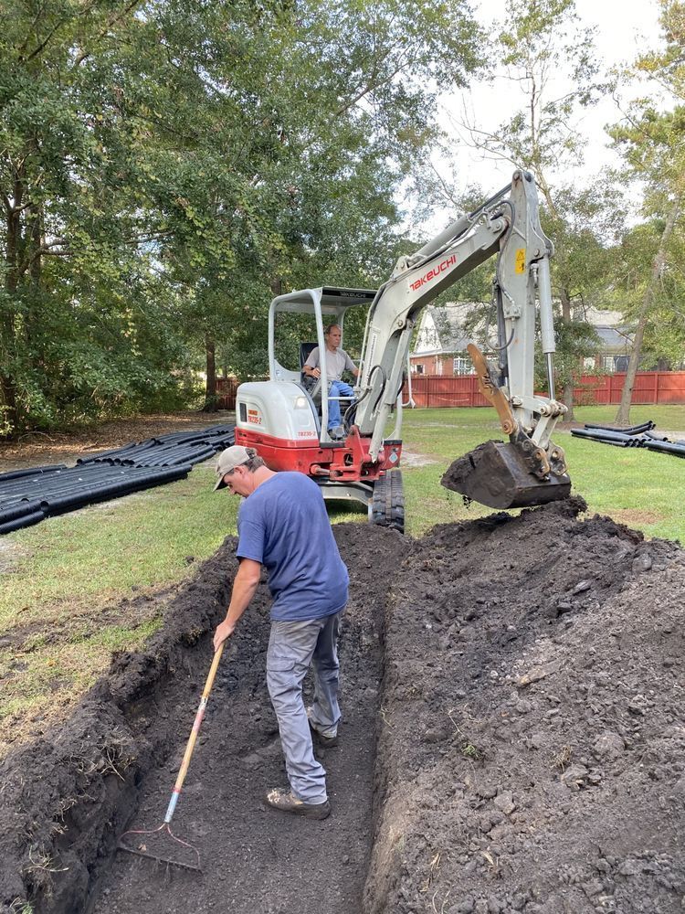 a man is digging a trench in front of a takeuchi excavator