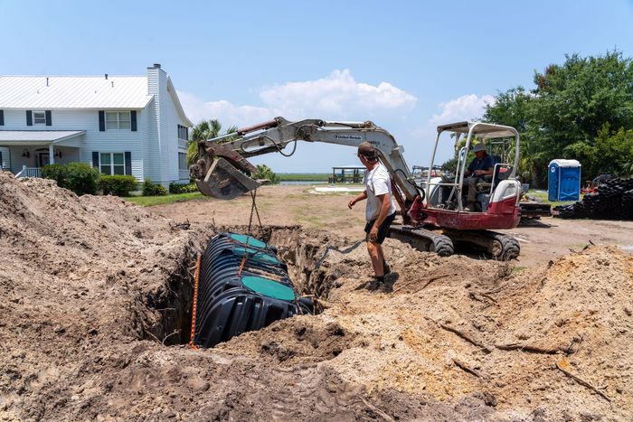 a man stands in front of an excavator that says takeuchi