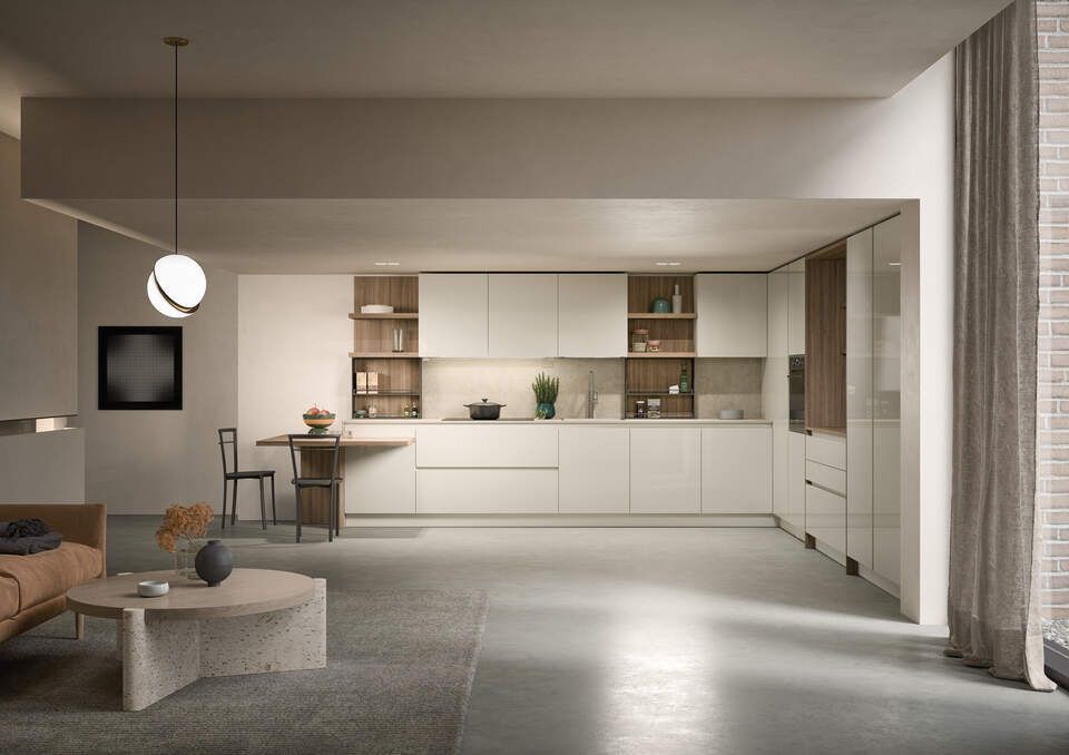 Un soggiorno con divano, tavolo, sedie e una cucina.