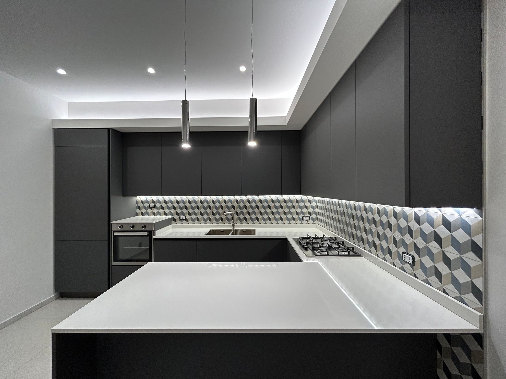 Una cucina con mobili neri e ripiano bianco