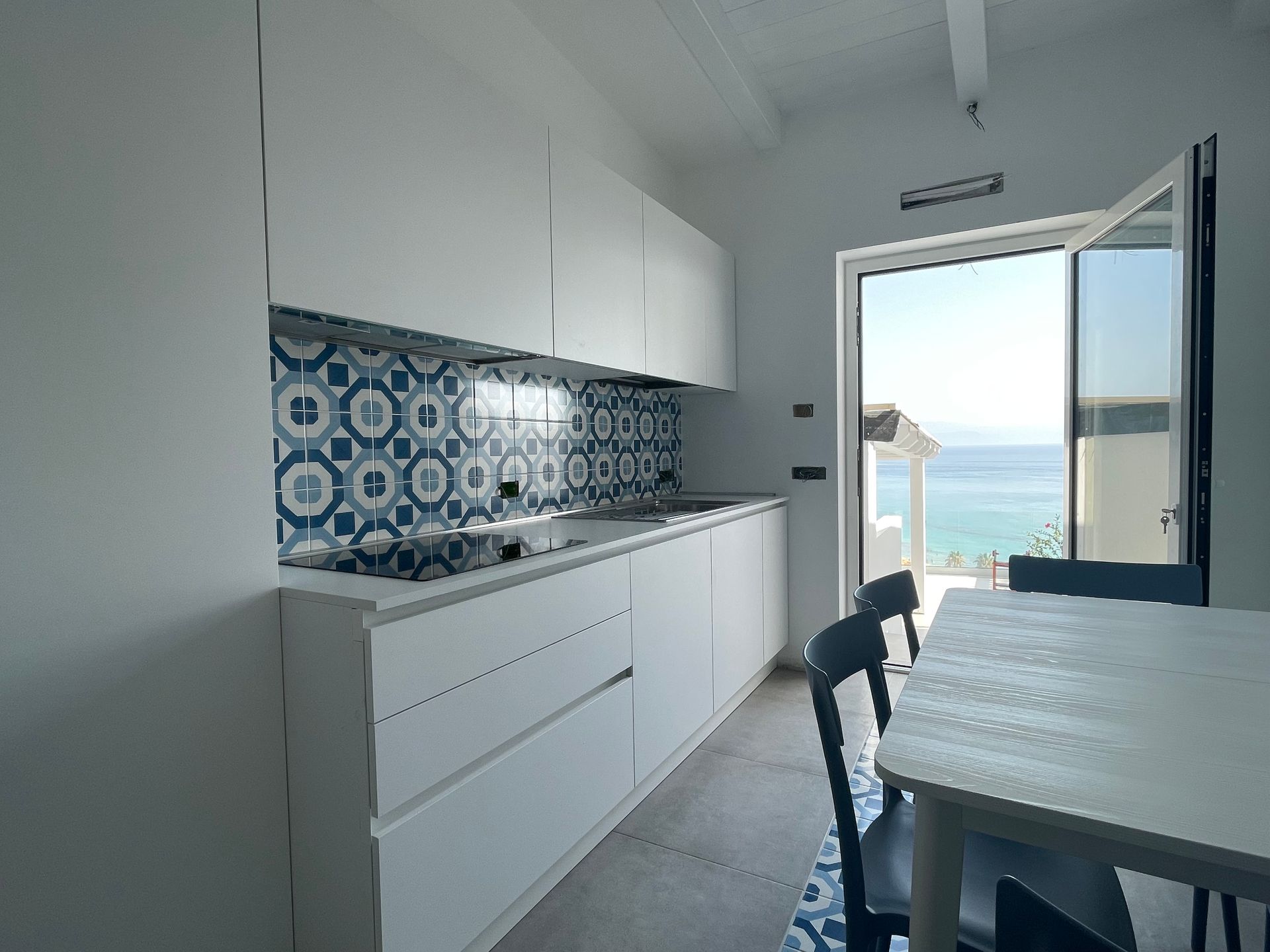 Una cucina con tavolo e sedie e vista sull'oceano.