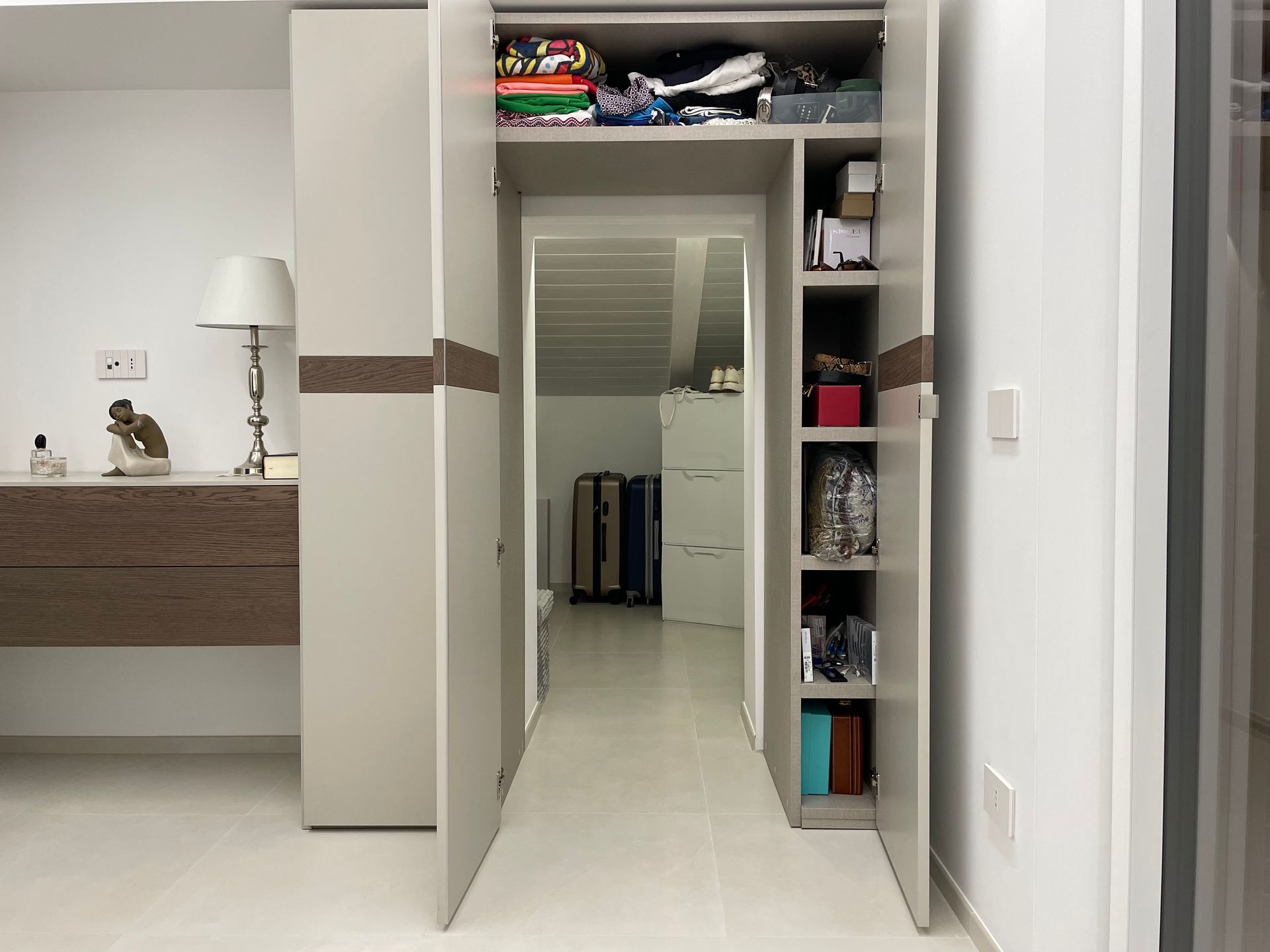 Un corridoio conduce ad una camera da letto con una lampada a muro