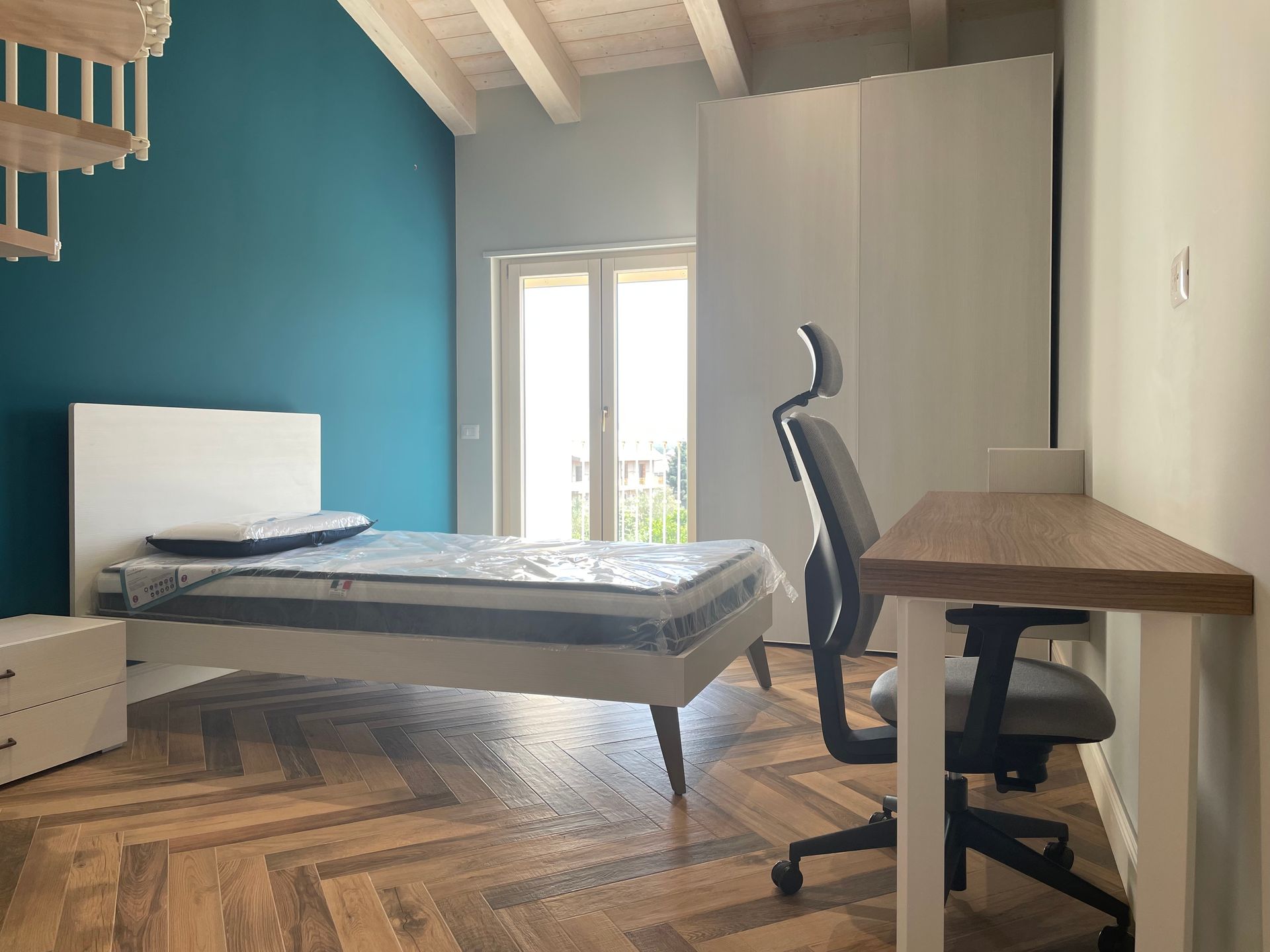 Una camera da letto con letto, scrivania e sedia