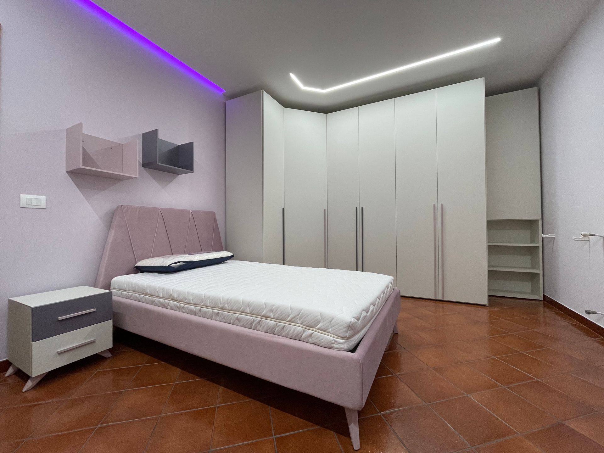 Una camera da letto con letto, comodino e armadio.