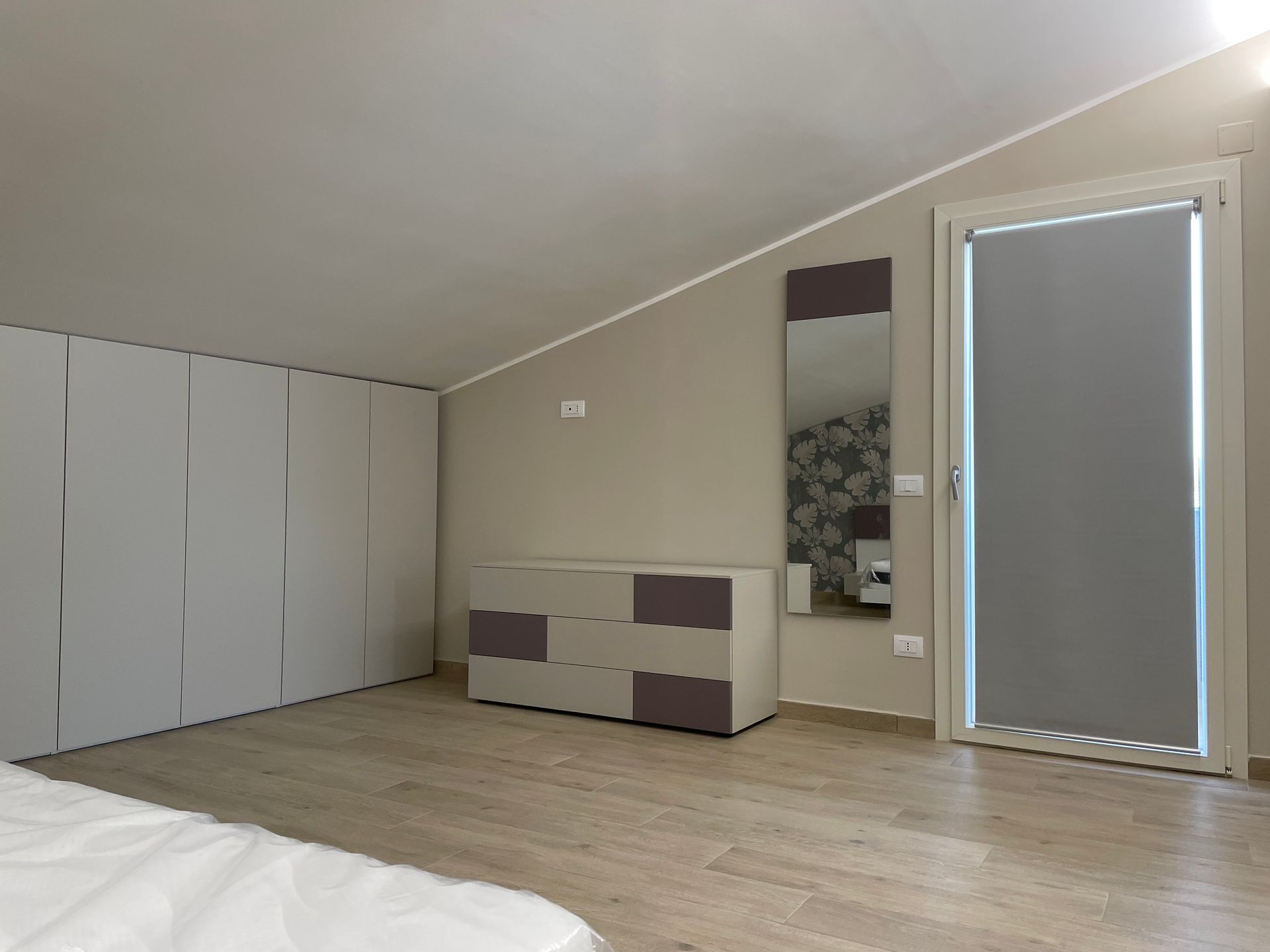 Una camera da letto con un comò e uno specchio sul muro