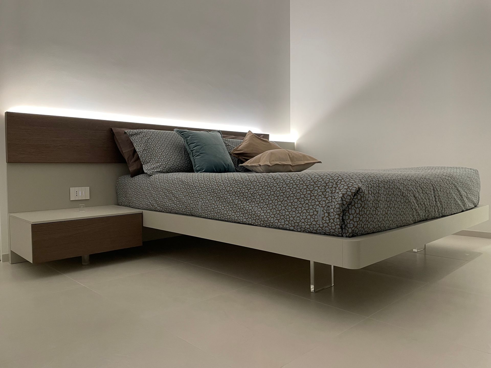 Un letto con un comodino accanto in una camera da letto.