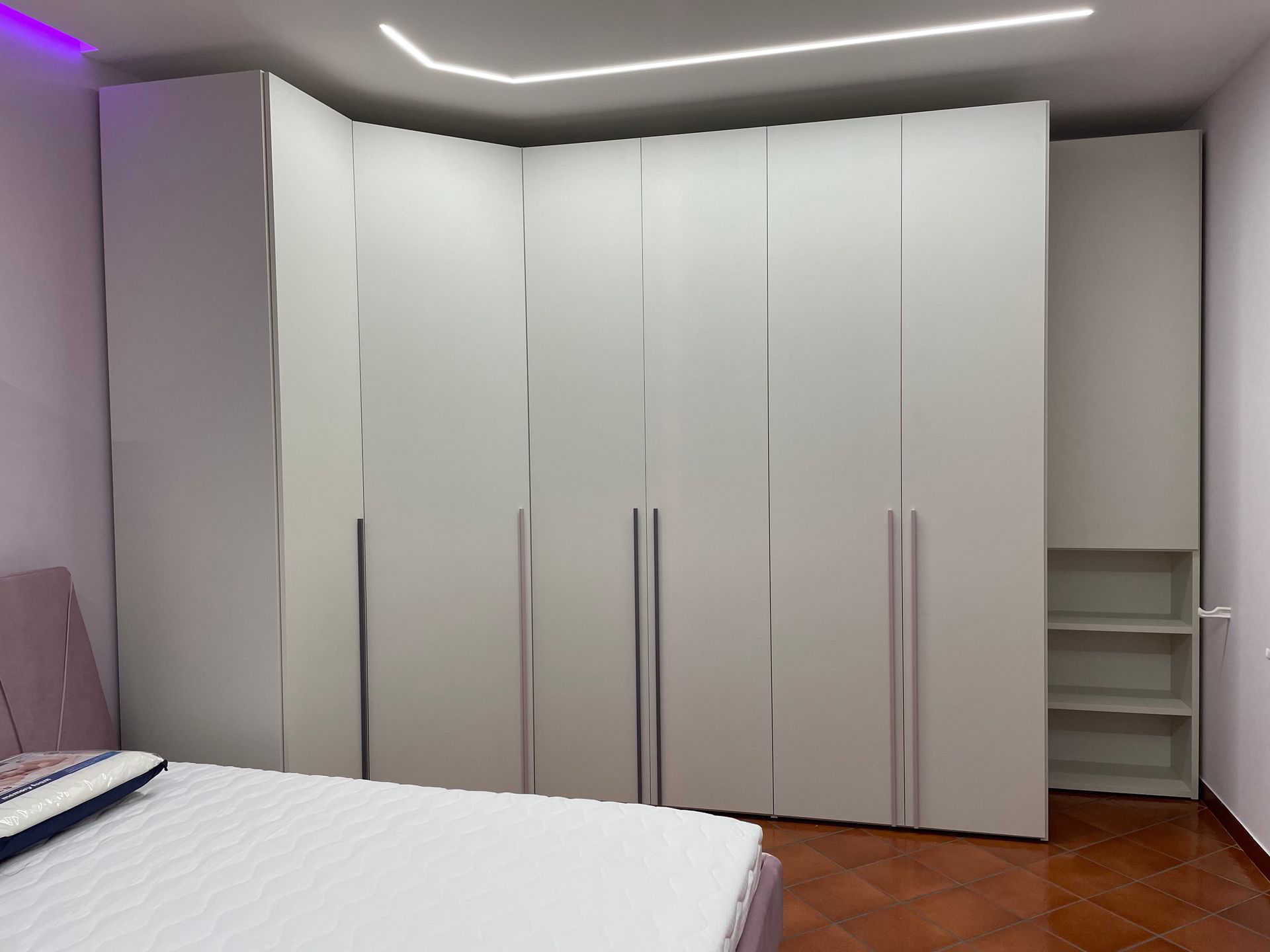 Una camera da letto con un letto e un grande armadio bianco