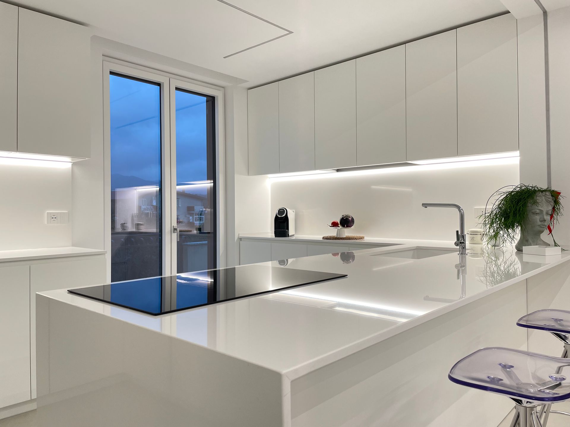 Una cucina con mobili bianchi e una grande isola con forno.