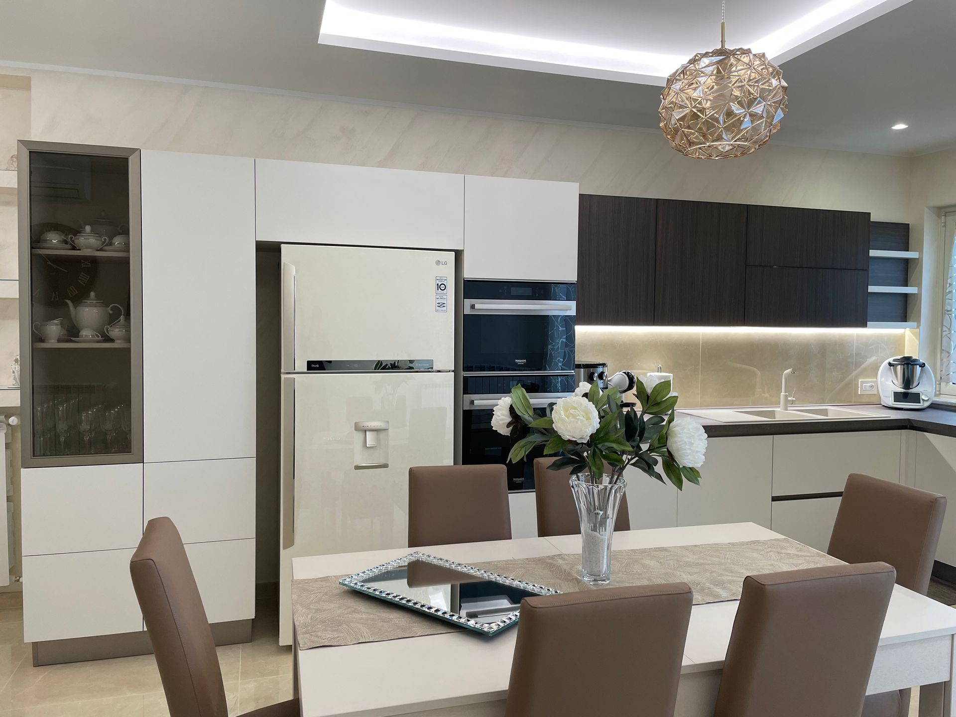 Una cucina con tavolo e sedie e frigorifero.