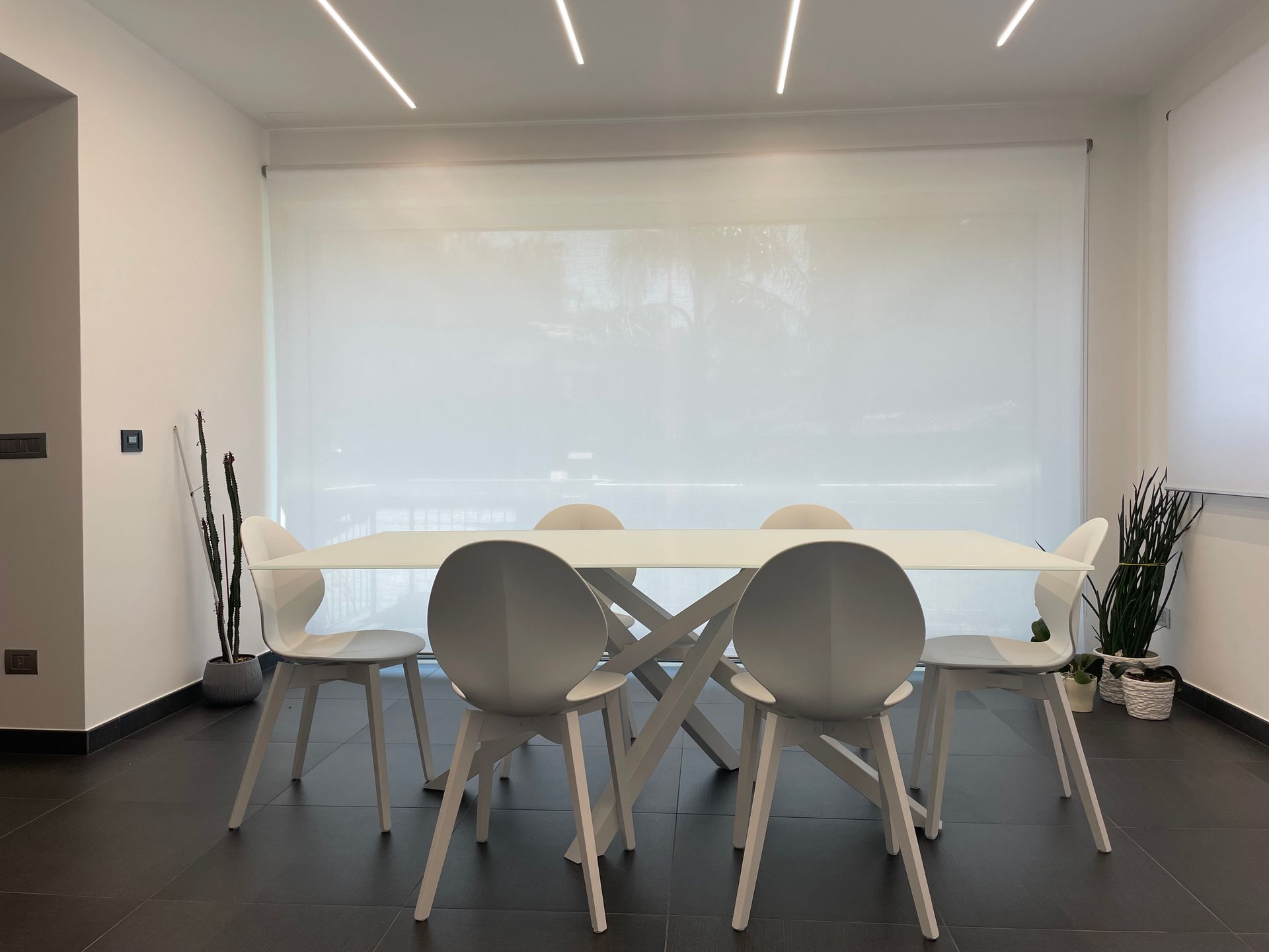 Una sala da pranzo con tavolo e sedie davanti a una finestra.