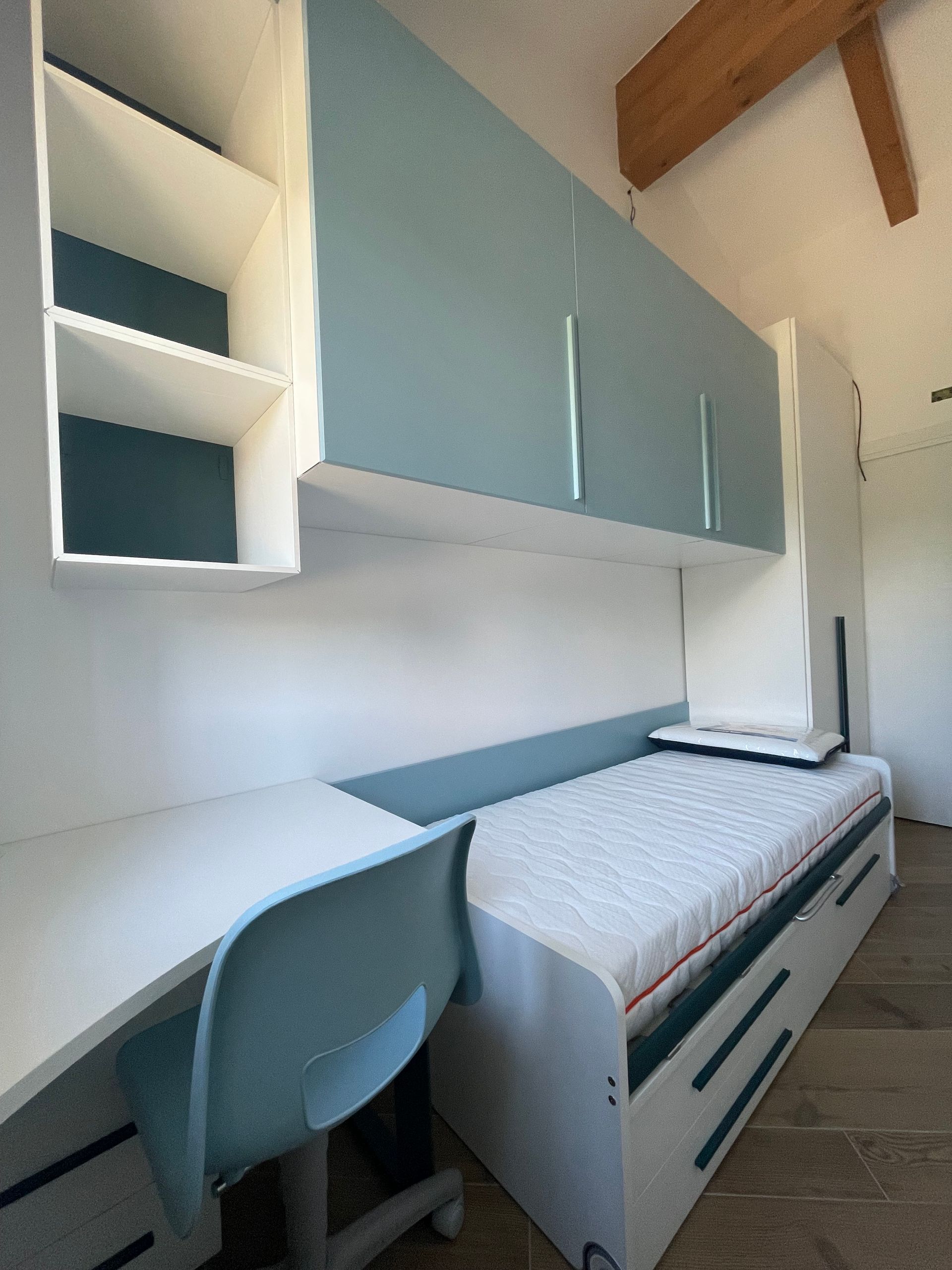Una camera con un letto singolo e una scrivania