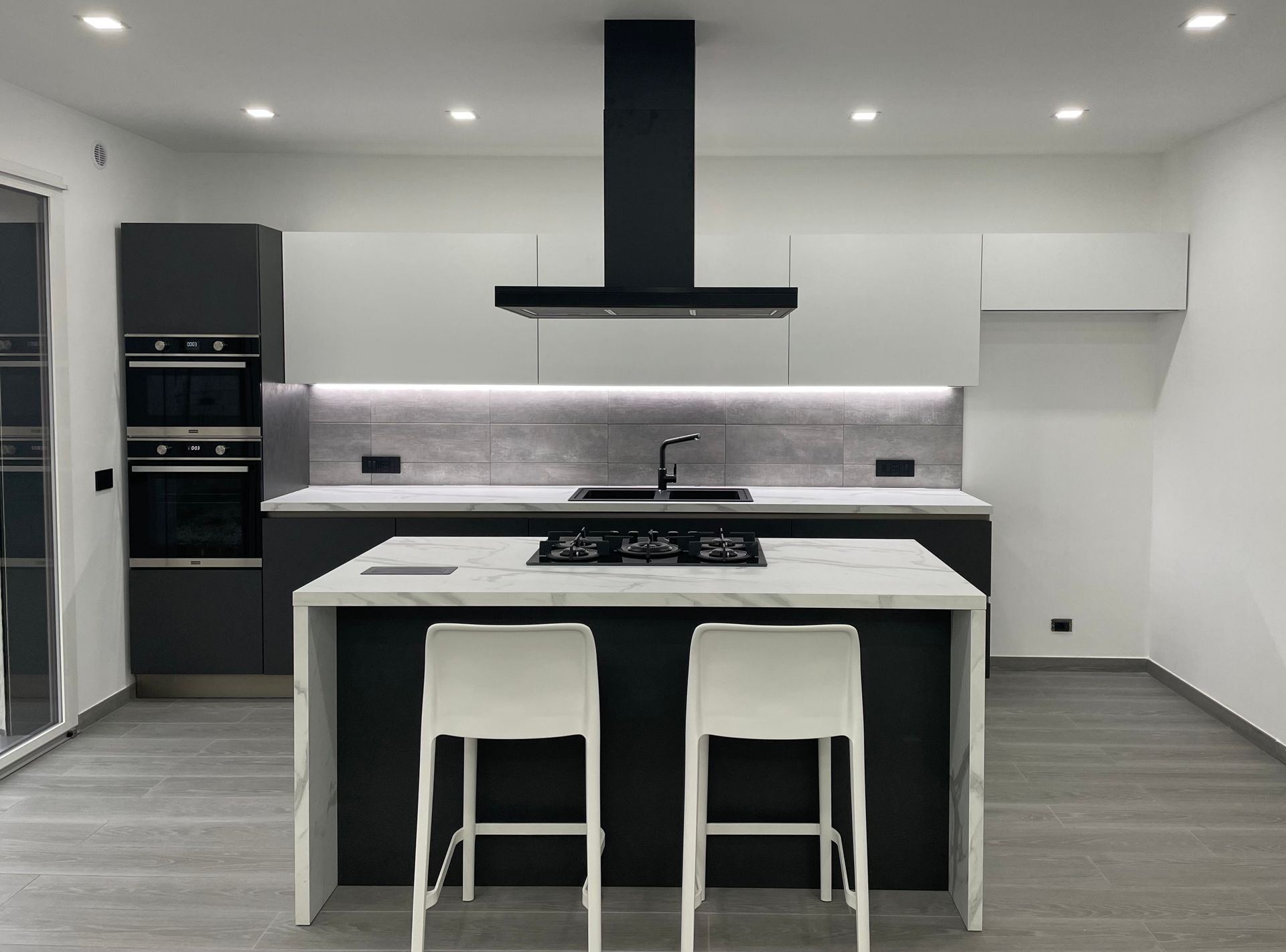 Una cucina con una grande isola e due sgabelli