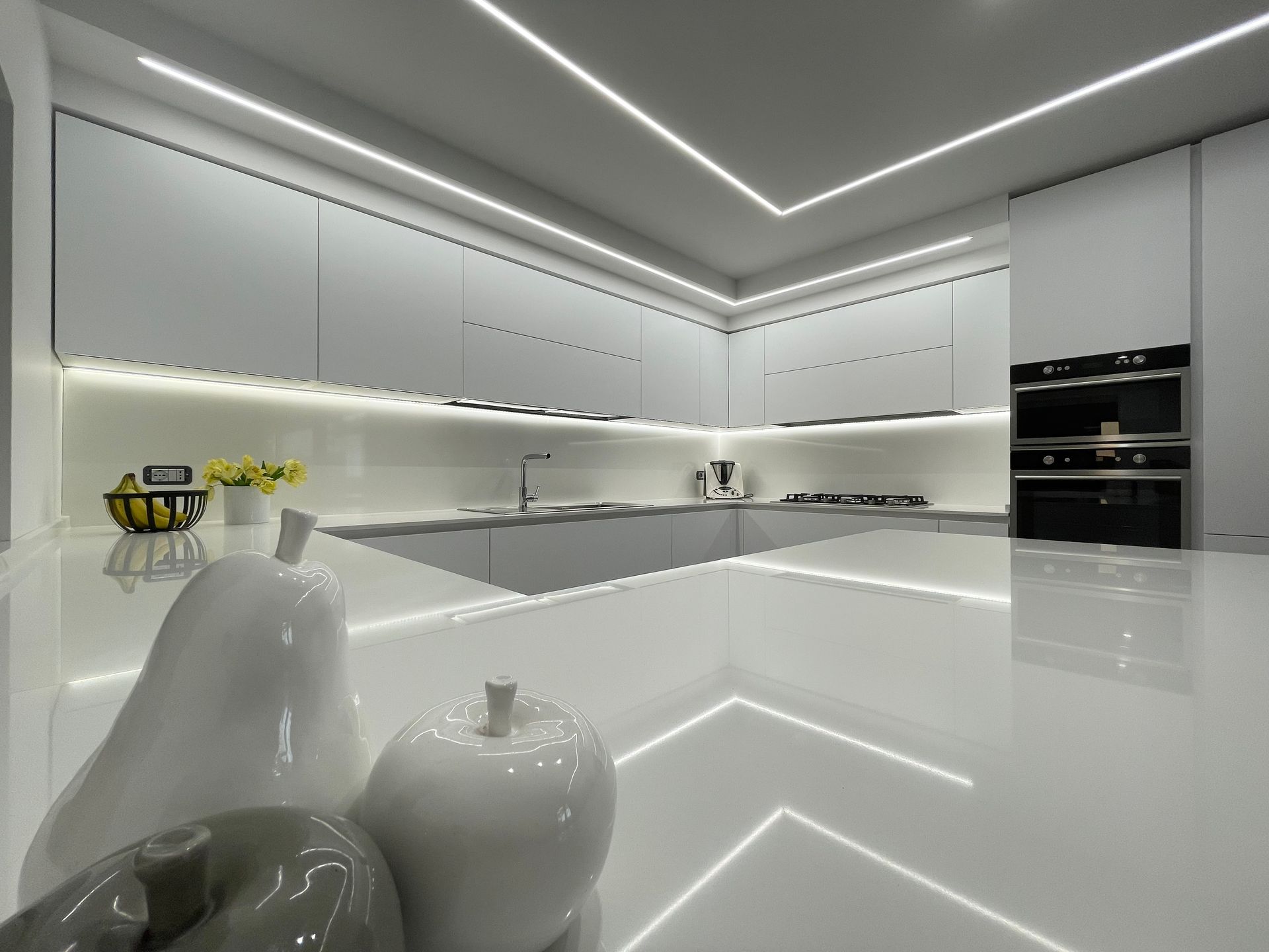 Una cucina con mobili bianchi e ripiano bianco