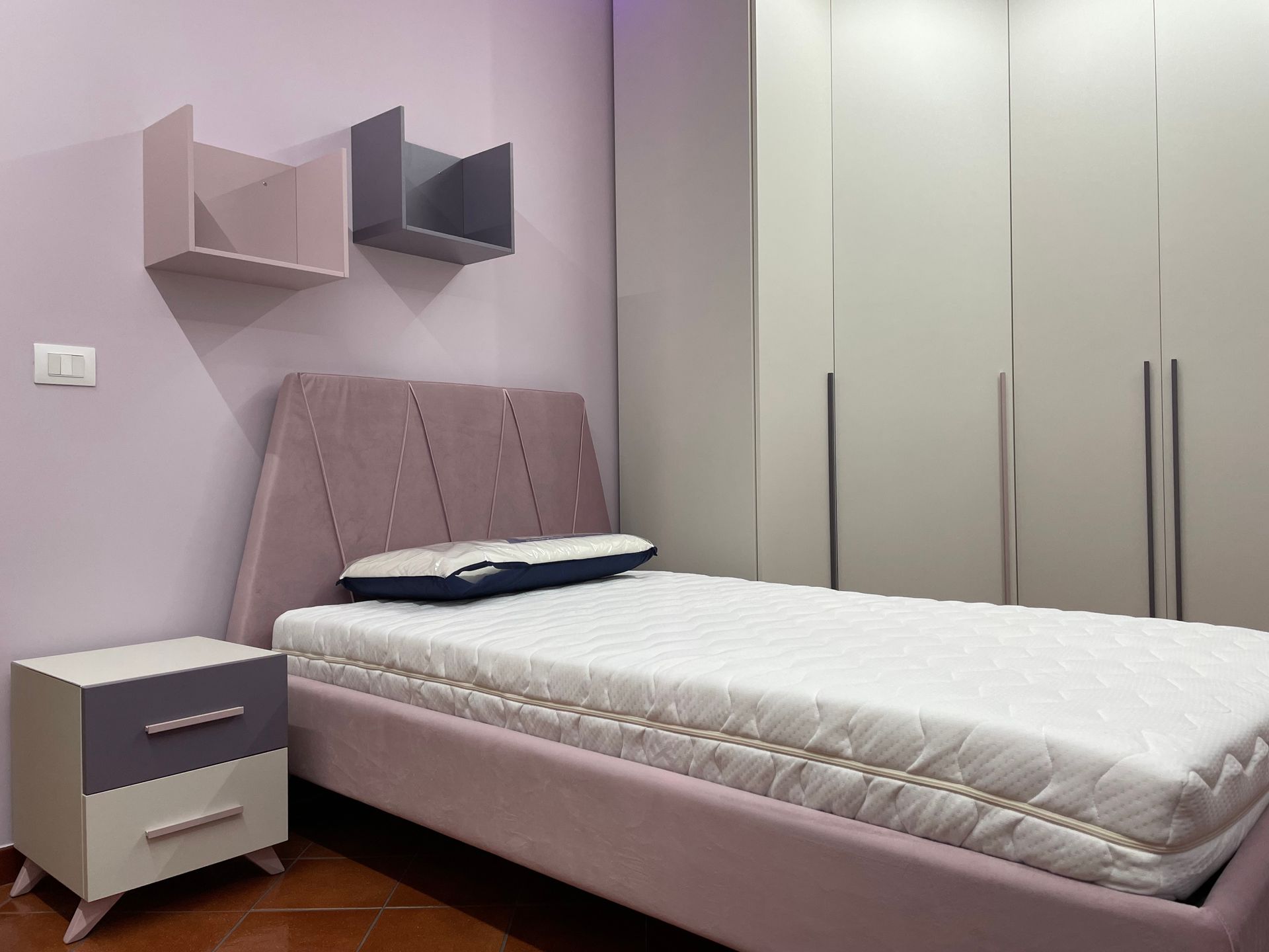 Una camera da letto con letto, comodino e armadio.