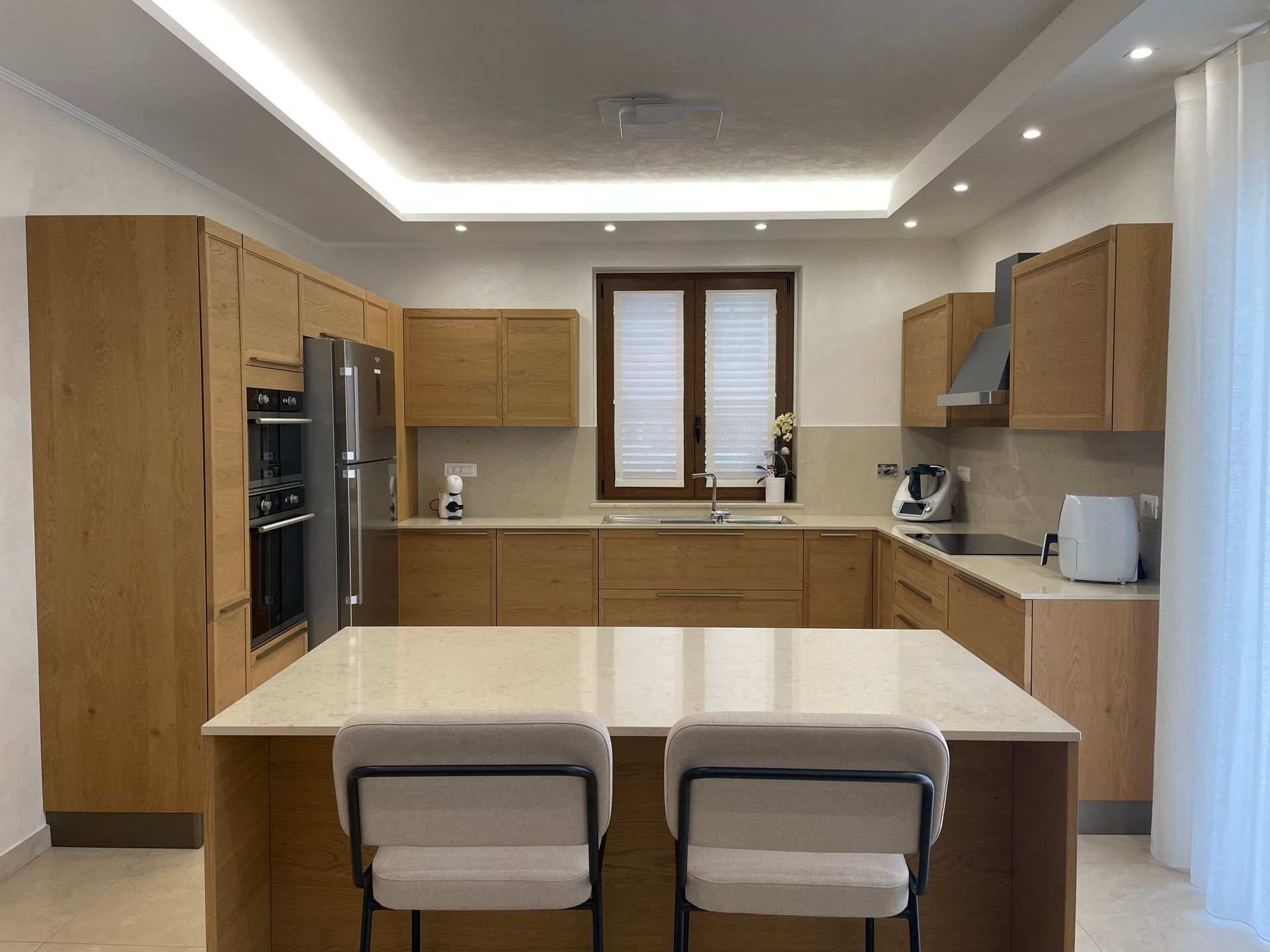 Una cucina con mobili in legno ed elettrodomestici in acciaio inossidabile