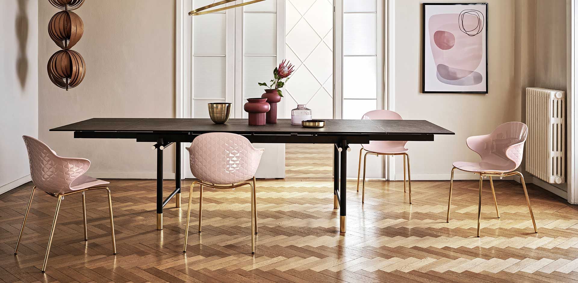 Una sala da pranzo con tavolo e sedie e pavimento in legno.
