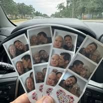 Photo booth strips held in a car, showing a smiling couple posing together.