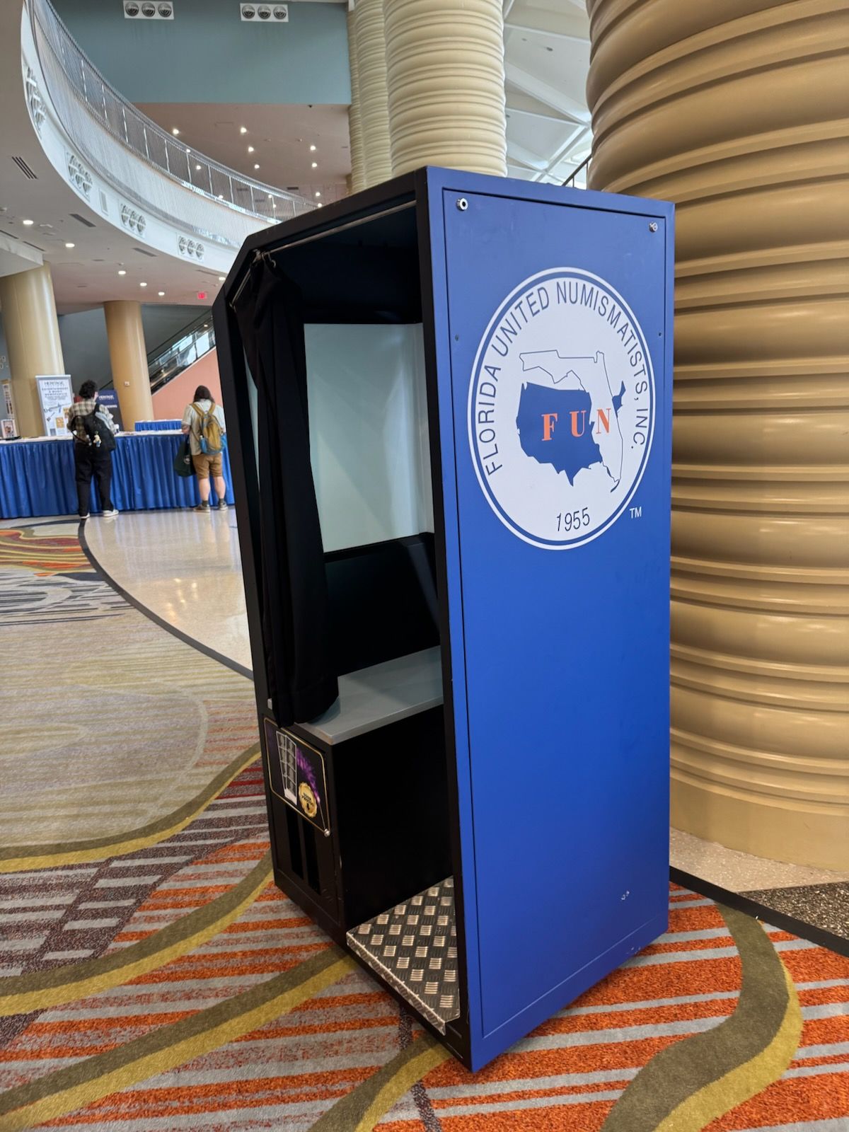 Blue and black photo booth with Florida Farm Bureau logo in a convention hall.