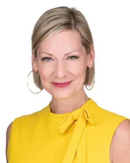 Portrait of a smiling woman in a bright yellow sleeveless top on a white background
