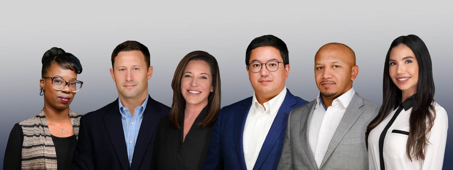 Six business professionals posing in a row against a light background.