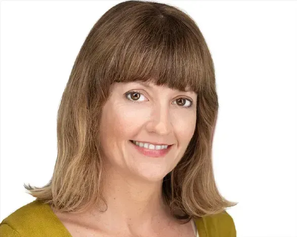 Smiling woman with shoulder-length light brown hair on a white background
