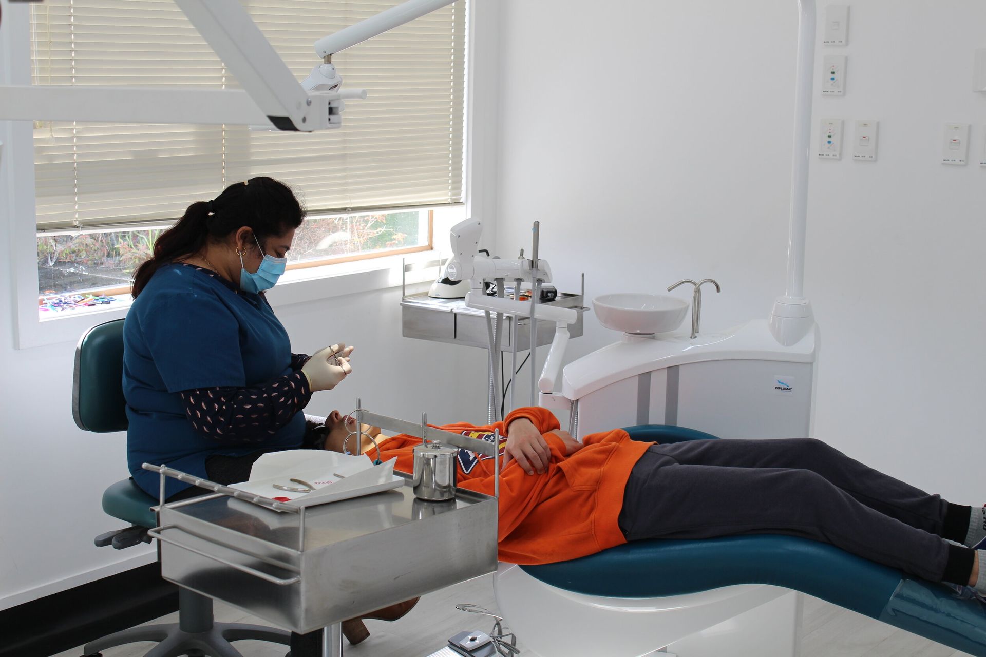 A dentist is examining a patient 's teeth in a dental office.