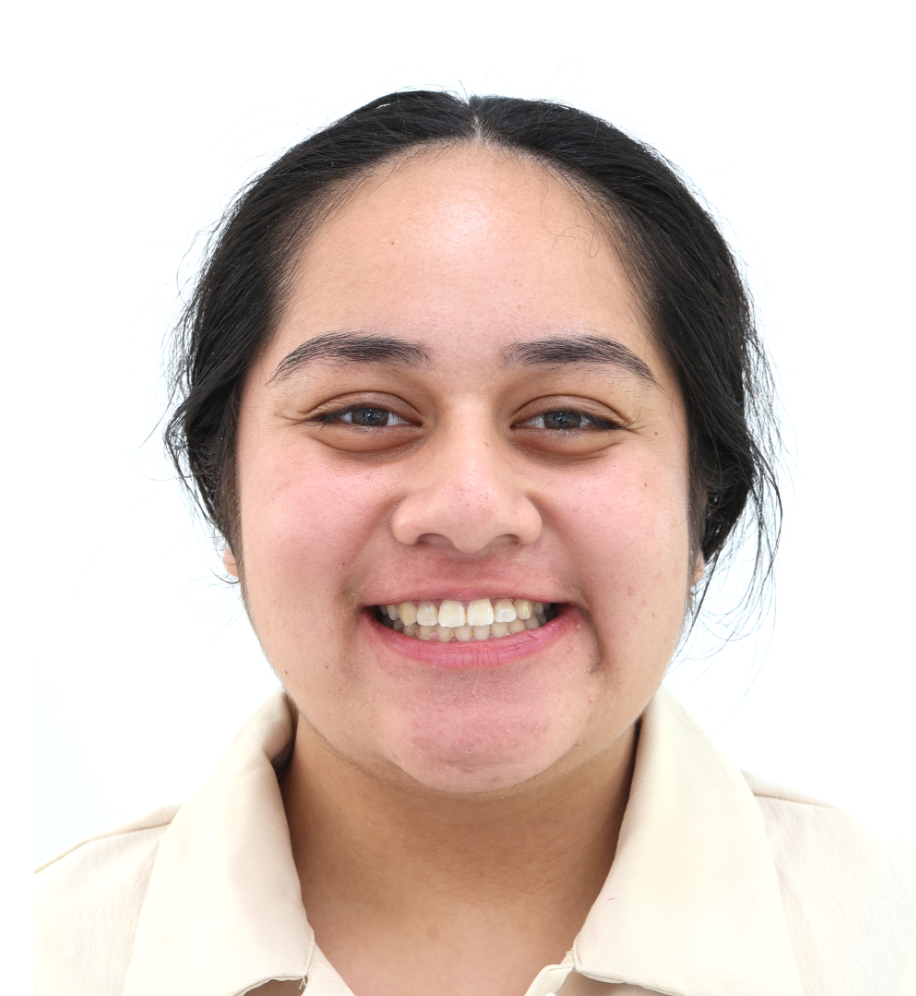 A woman is smiling and wearing a white shirt