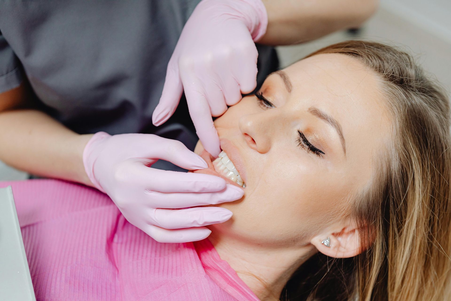 A woman is getting her teeth examined by a dentist.
