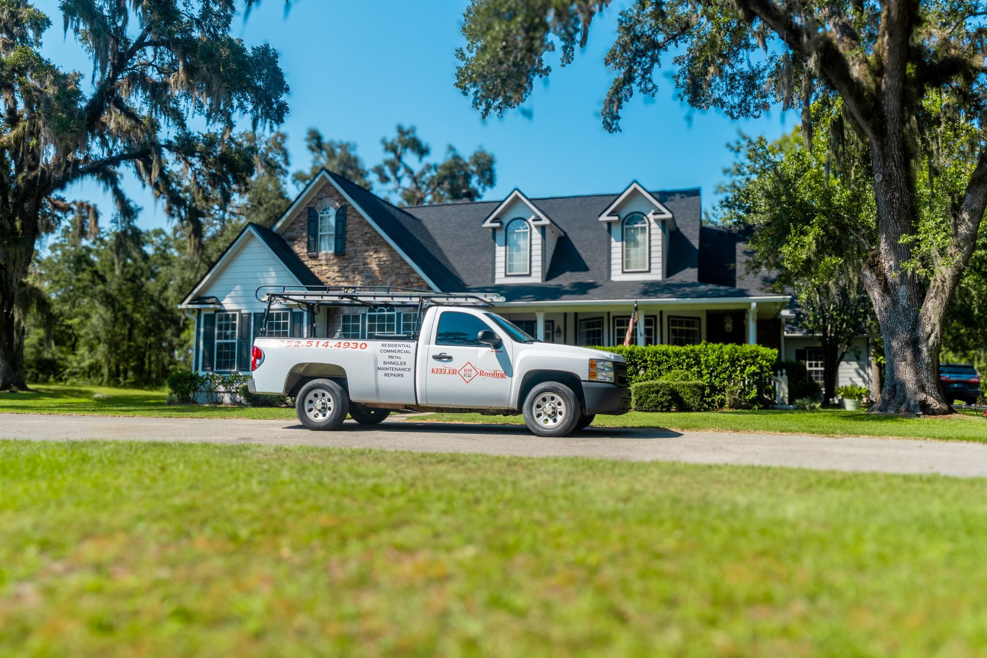 Explore this spacious suburban home design featuring a prominent glass sunroom, brick accents, and a wide backyard view. A perfect example of functional, multi-level outdoor access and coastal-inspired architecture.