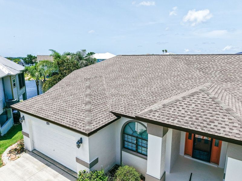 Vew of a modern asphalt shingle roof under bright Florida sunlight.