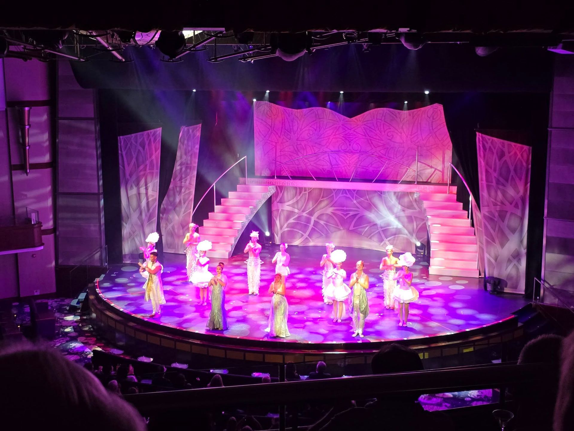 A group of dancers on a stage with purple lights
