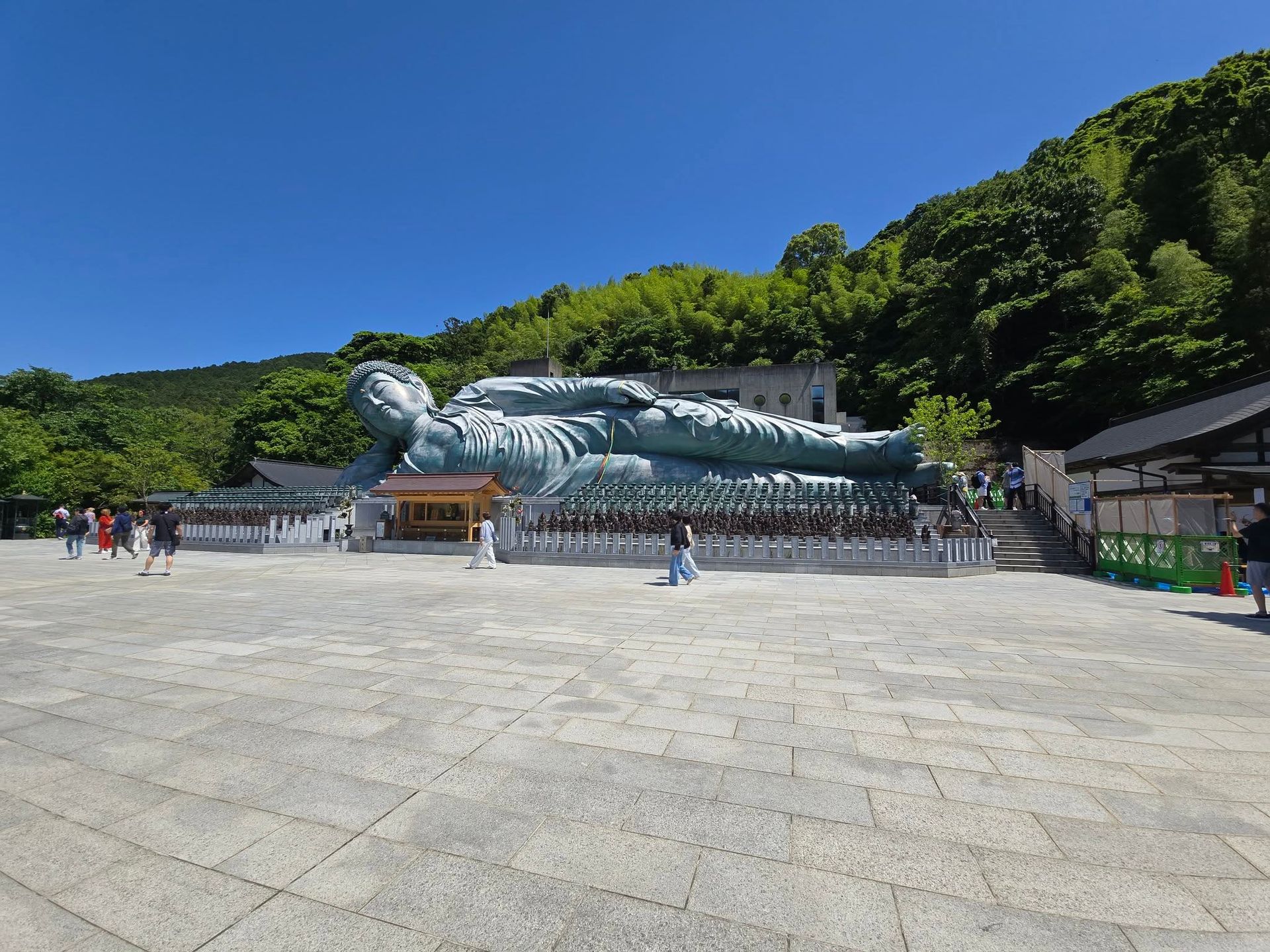 A large statue of a person laying down in a park