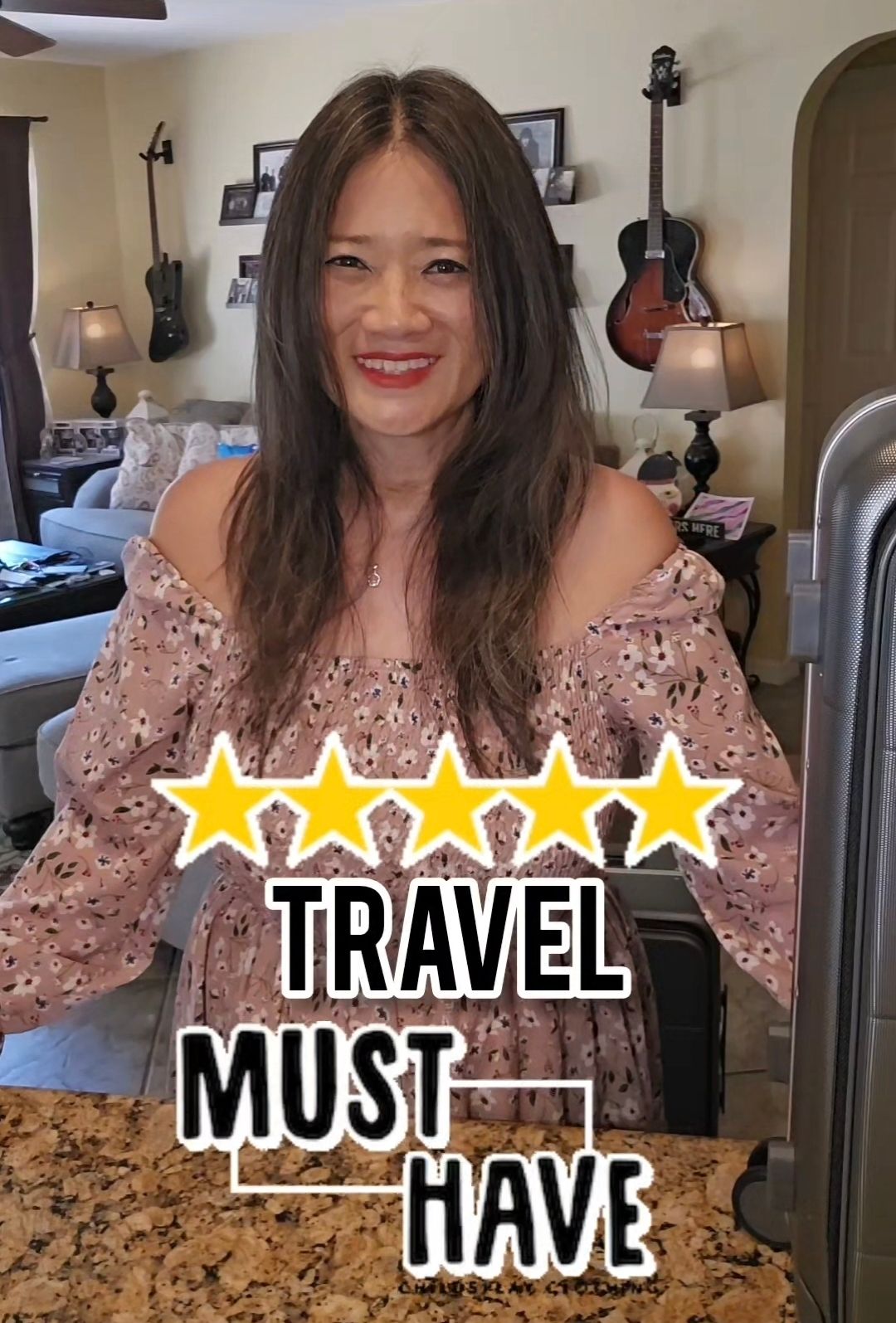 A woman is standing in a living room with a sign that says `` travel must have ''.