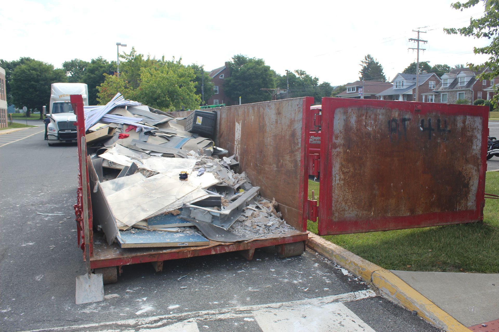 The dumpster is getting filled with demolition debris.