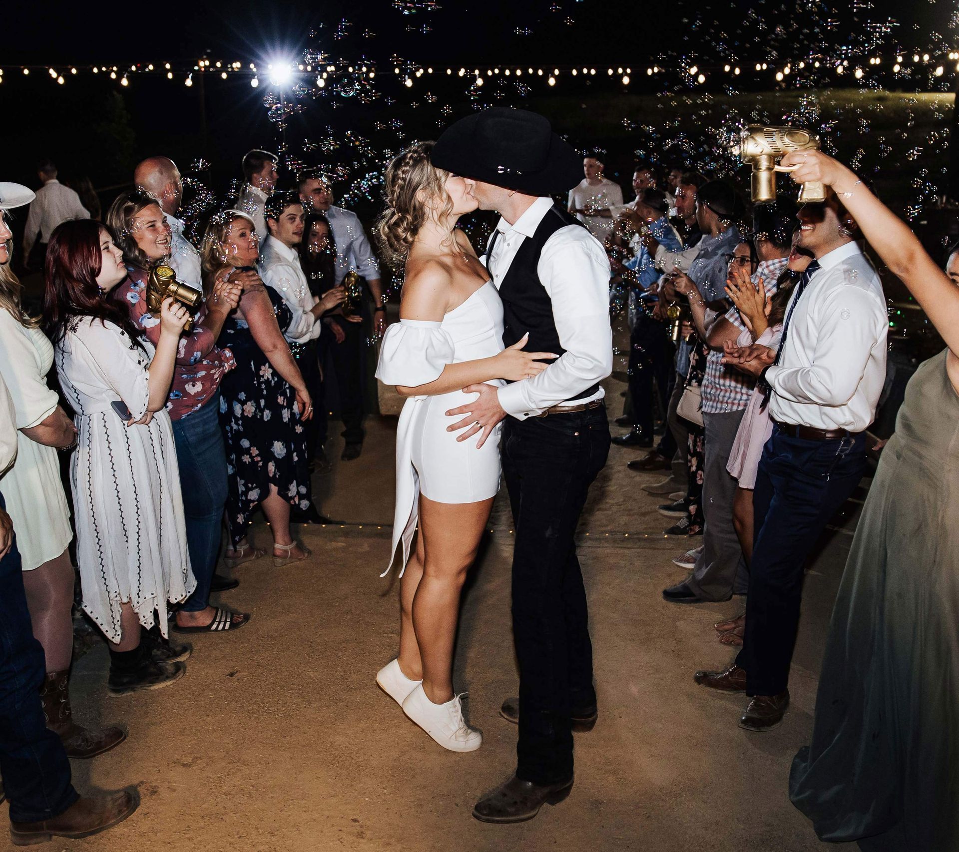 a bride and groom kiss in front of a crowd of people