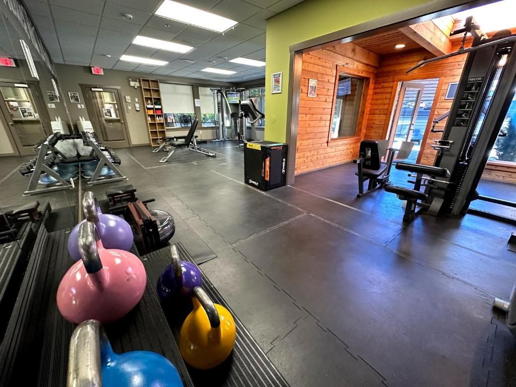 Het interieur van een sportschool met oefenballen, apparatuur en een trainingsruimte met bakstenen muren.