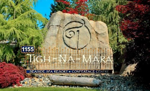Toegangsbord voor Tigh-Na-Mara Seaside Spa Resort and Conference Centre met een logo van gehouwen steen en groen.