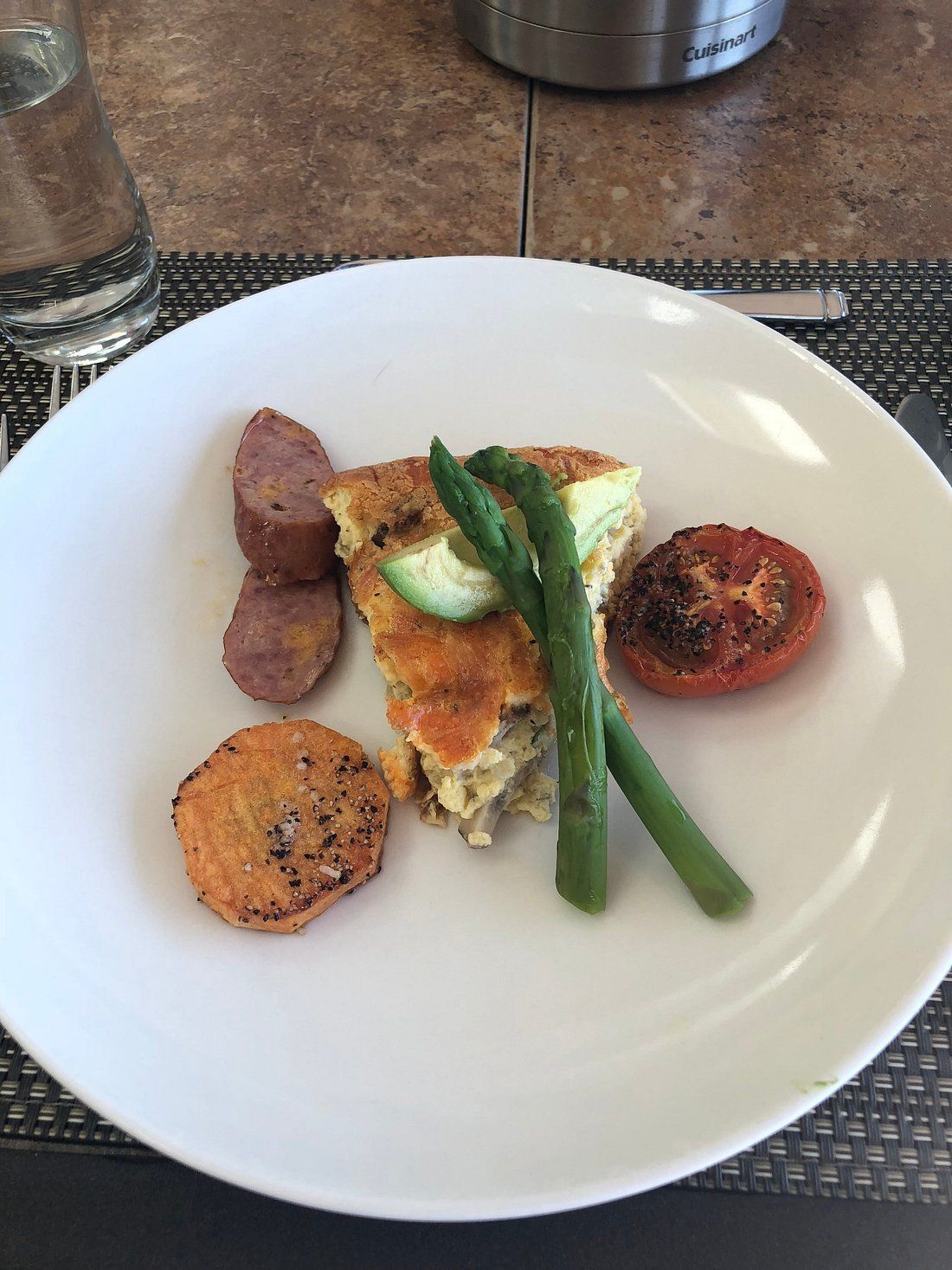 Een prachtig opgemaakt gastronomisch gerecht met asperges, gebakken groenten en een romige vulling op een wit bord.